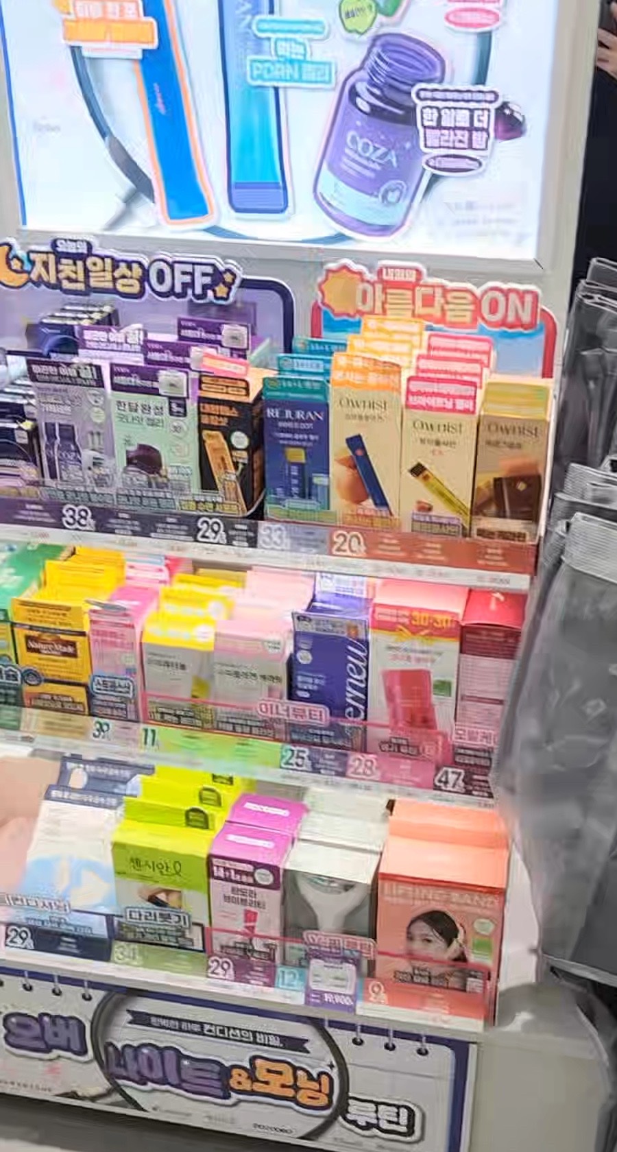 A densely packed Olive Young display shelf, every product label and promotional sign written in Korean.